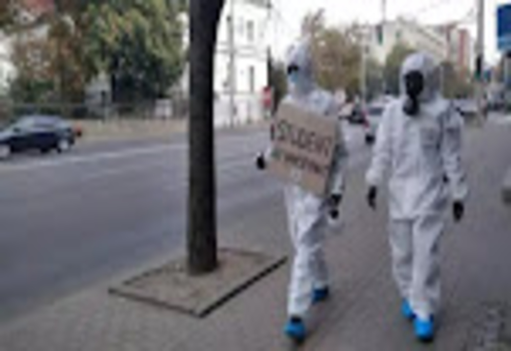Imaginea MOMENTULUI! Doi studenţi din Iași protestează împotriva vaccinării anti-Covid-19 îmbrăcați în combinezoane