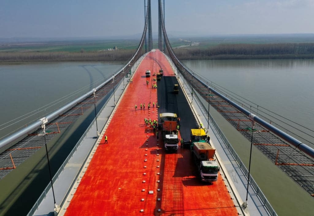 Astăzi a început așternerea primului strat de asfalt pe podul suspendat peste Dunăre